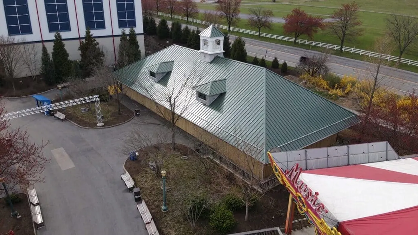 Aerial view of a pale green metal roof and white building in the Strack Hill Roofing gallery