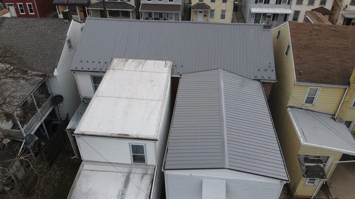 Aerial view of adjoining white and gray metal roofs