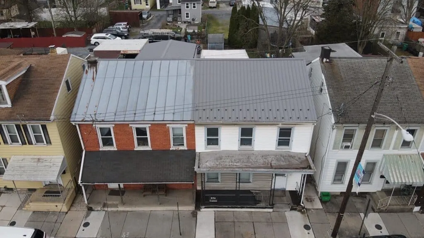 Aerial view of a gray metal roof on a two-tone building