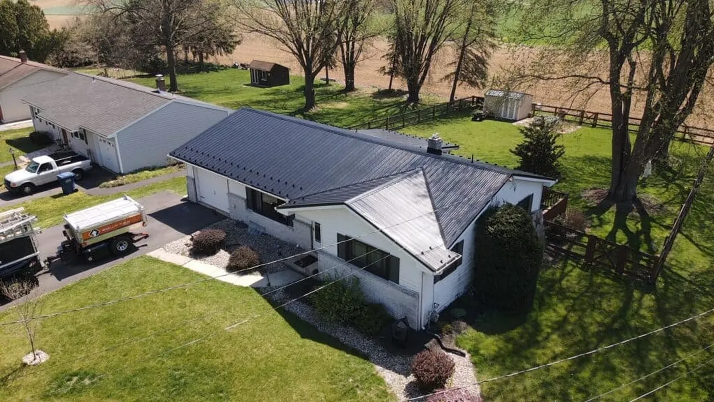 Aerial view of a dark metal roof on a white home