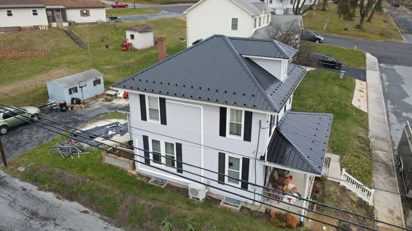 Completed gray metal roof on a white two-story home