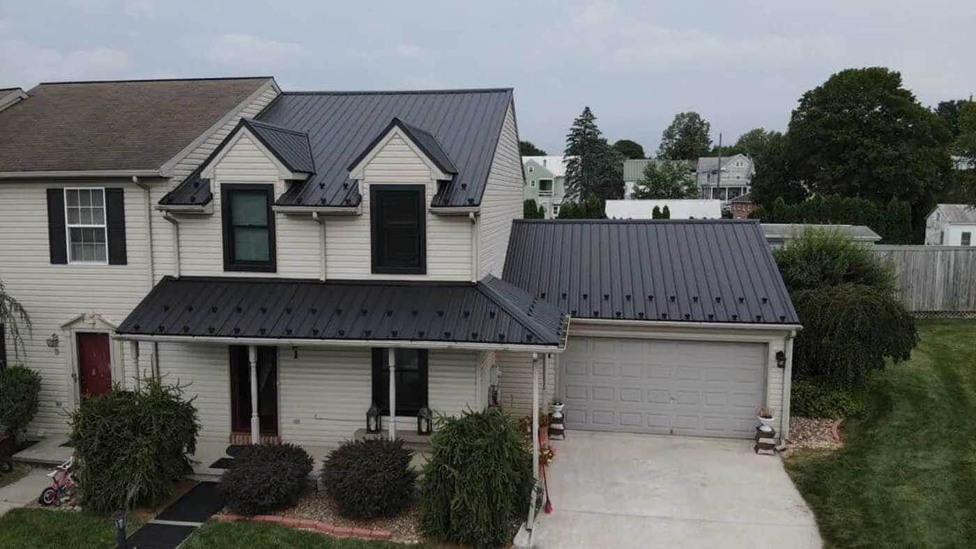 Completed dark metal roof on a white home